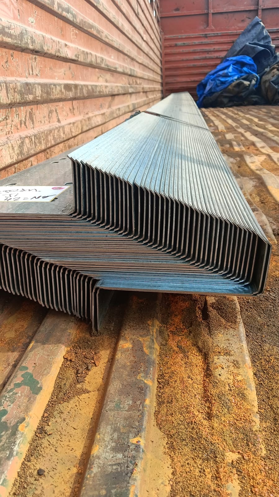 Stacked roll-formed Z-purlin steel sections loaded for dispatch